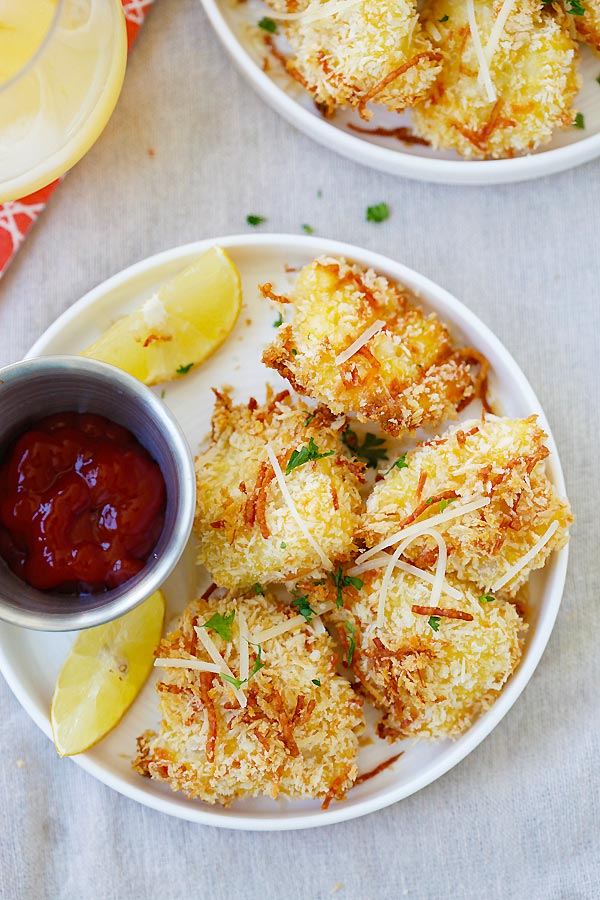 Parmesan Baked Fish Nuggets with cod fish in a plate with a side of dipping sauce.