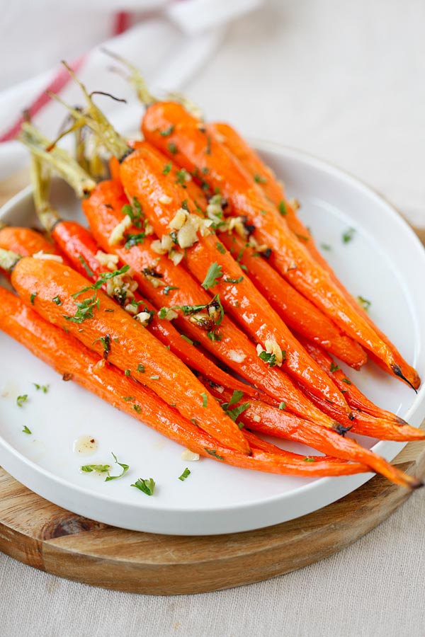 Easy homemade whole roasted carrots with honey, butter, garlic and parsley ready to serve.