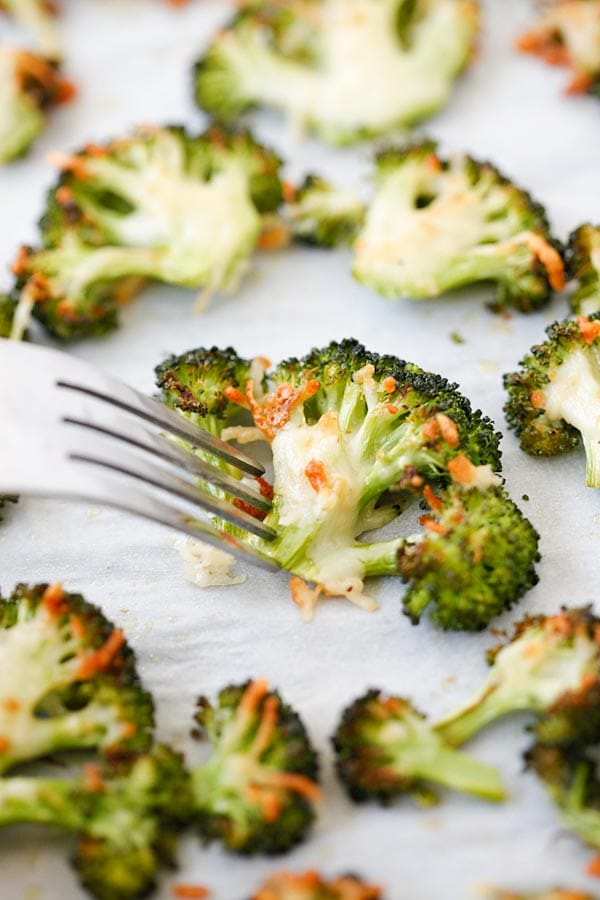 Parmesan Roasted Broccoli poked with a fork, ready to serve.