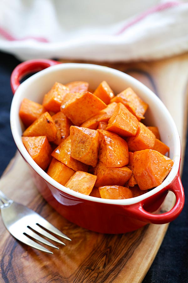 Easy and quick honey Cinnamon Roasted Sweet Potatoes in a red serving dish.