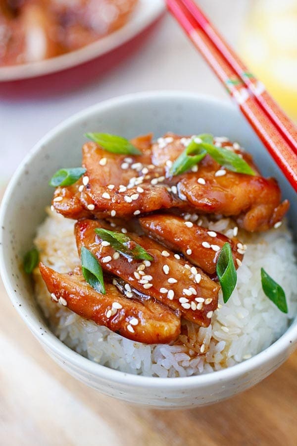 Chicken teriyaki in a rice bowl with a pair of Japanese chopsticks.