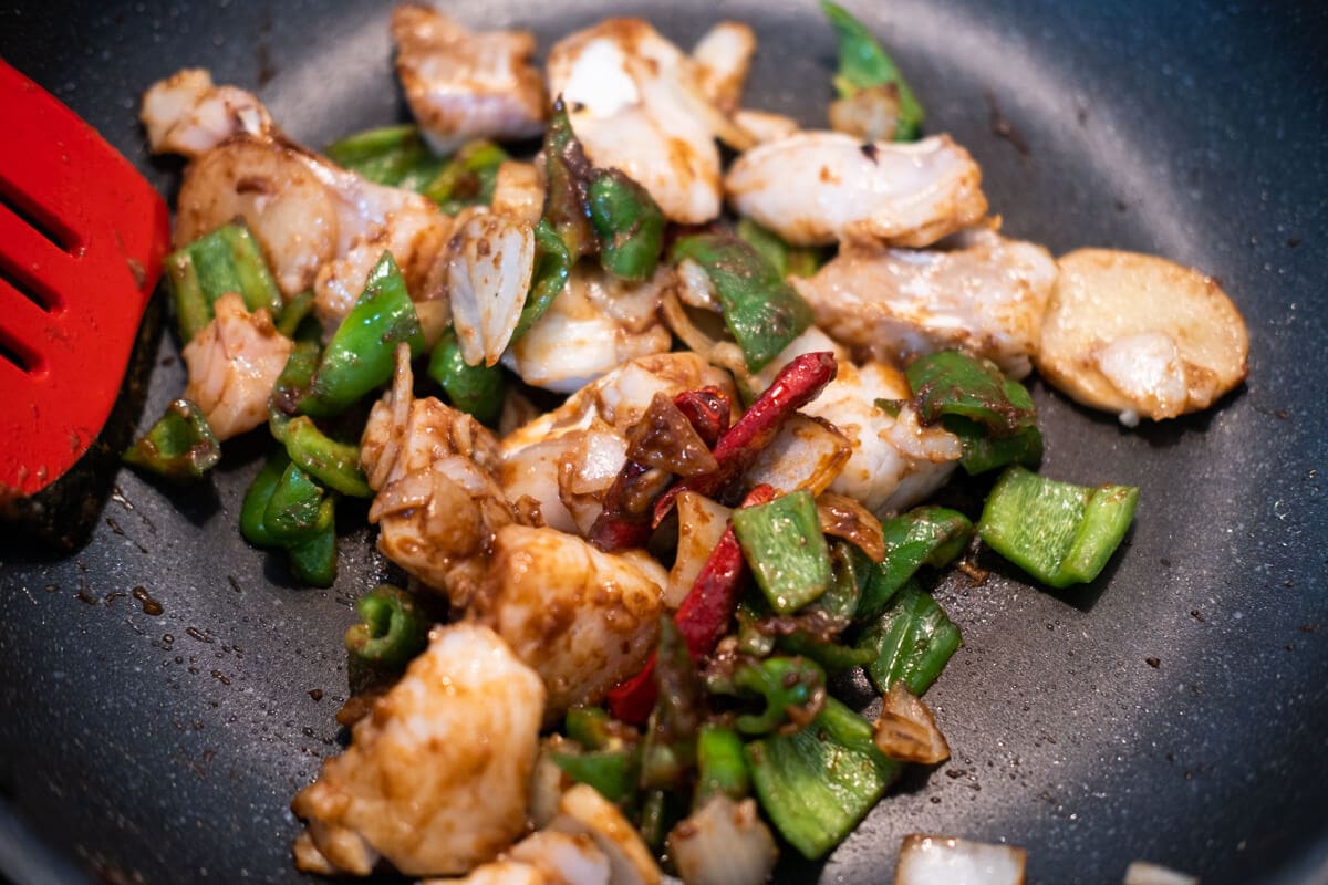 Add black bean sauce, fish sauce, sugar and sesame oil to the wok and stir-fry the fish. 