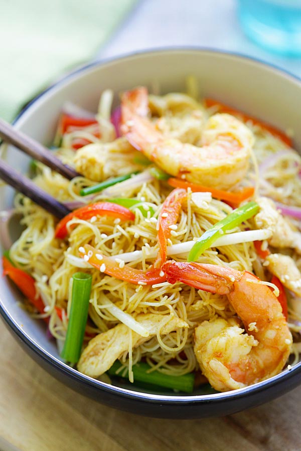 Singapore style rice noodles in a bowl and a pair of chopsticks.