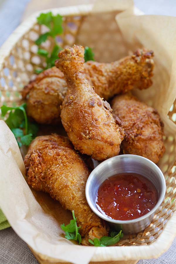 Thai street food style fried chicken drumsticks in basket.