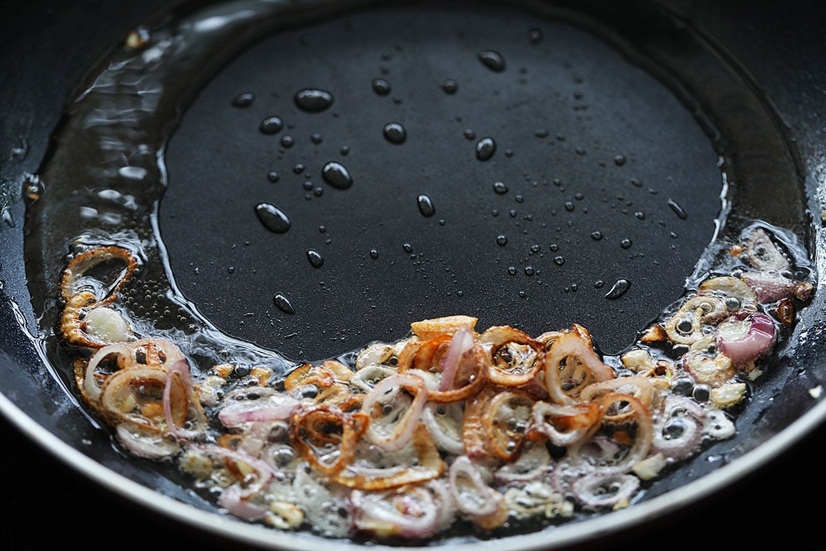 Making shallots oil in a skillet.