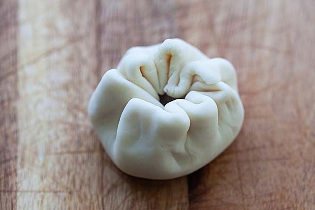 Wrapping chicken buns with steamed bun dough.