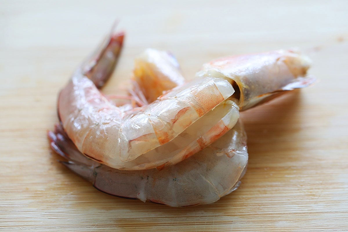 Cleaned prawns on a cutting board.