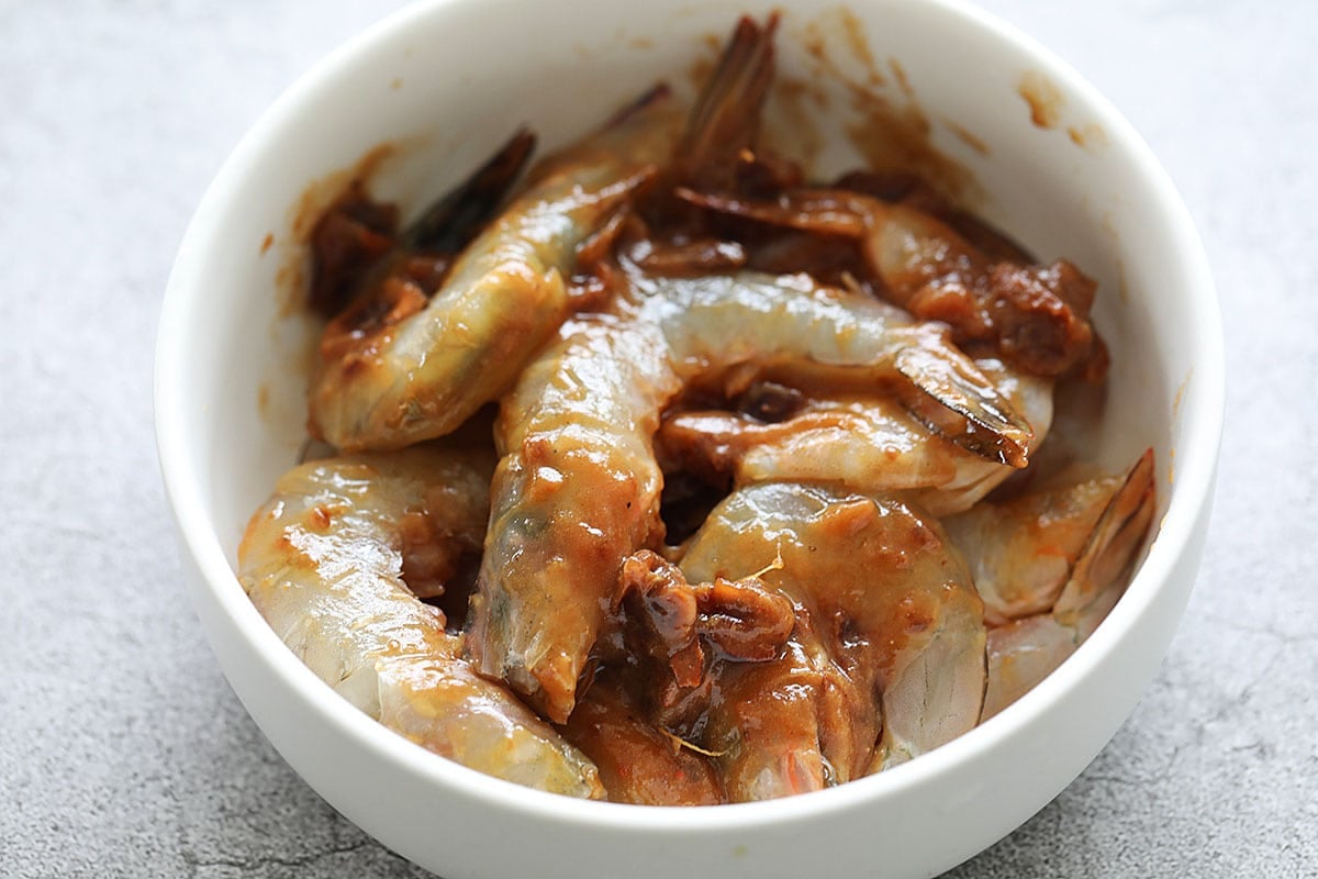 Marinating prawn with asam tamarind juice.