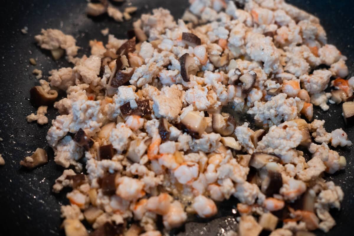 In a work, stir-fry garlic, chicken, shrimp, and mushrooms until cooked. 