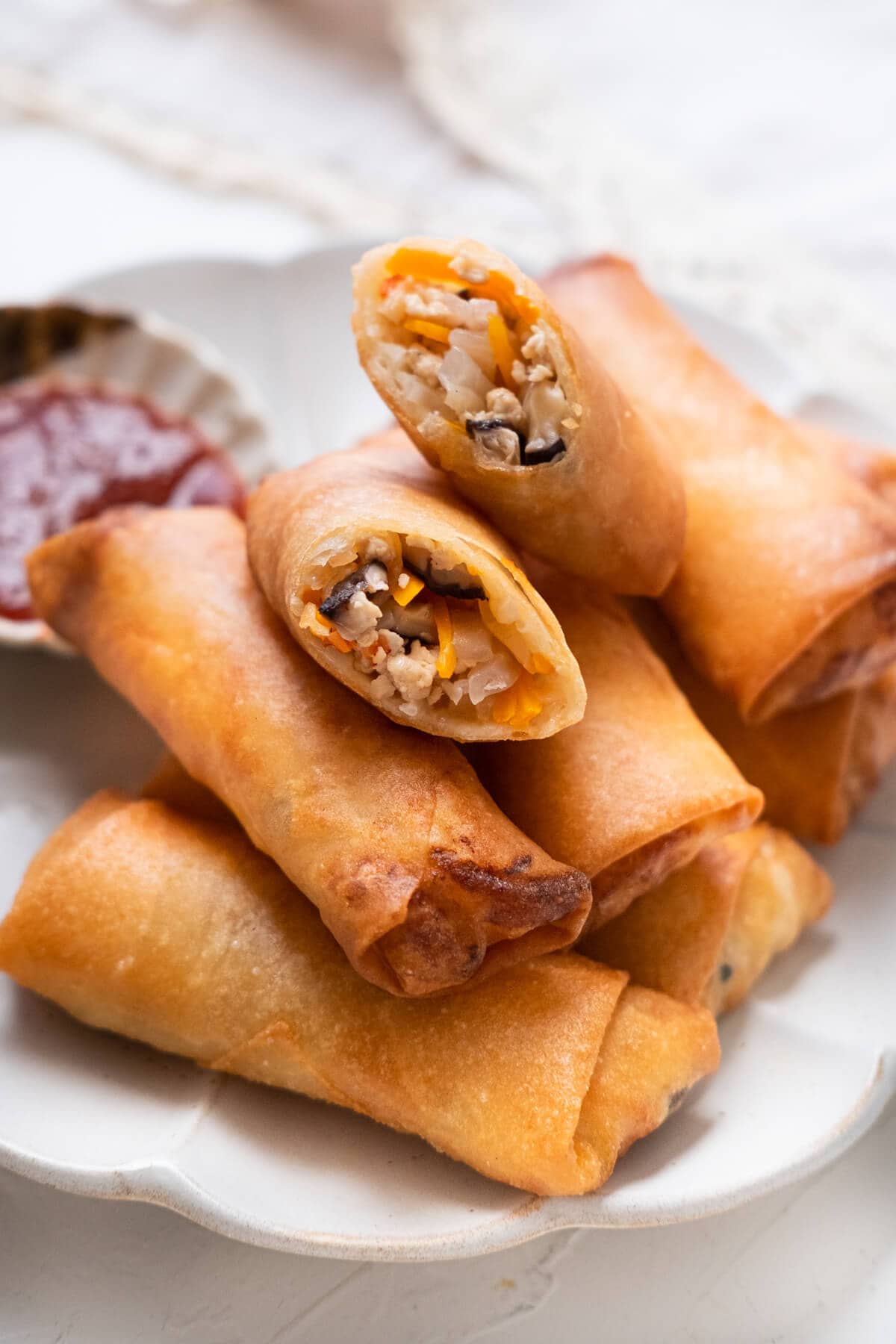 Fried spring rolls cut in half, revealing the popiah filling.