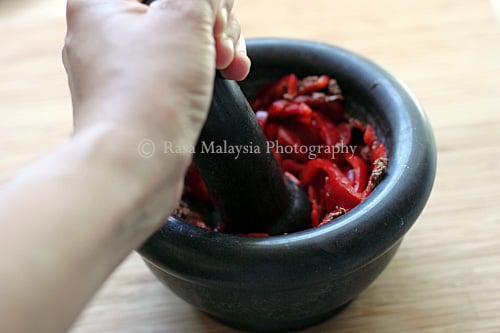 Pounding ingredients for Sambal Belacan.