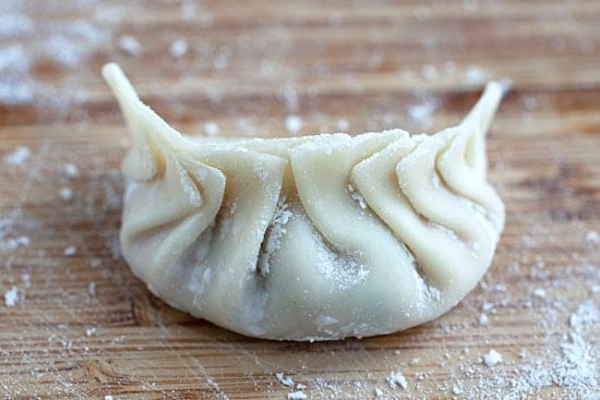 Wrapped dumpling with perfect pleats, ready to be steamed.