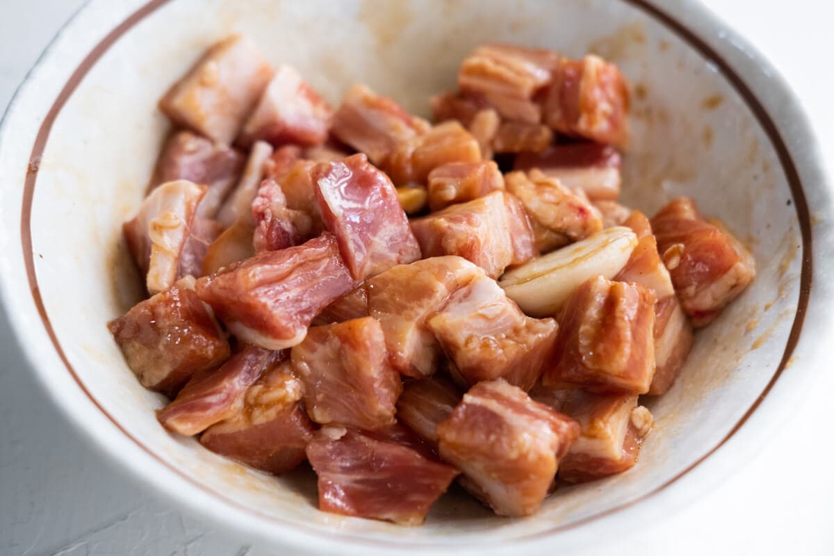 Marinated pork belly in a bowl.