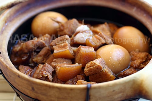 Close up of pork belly braised along with eggs in soy sauce.