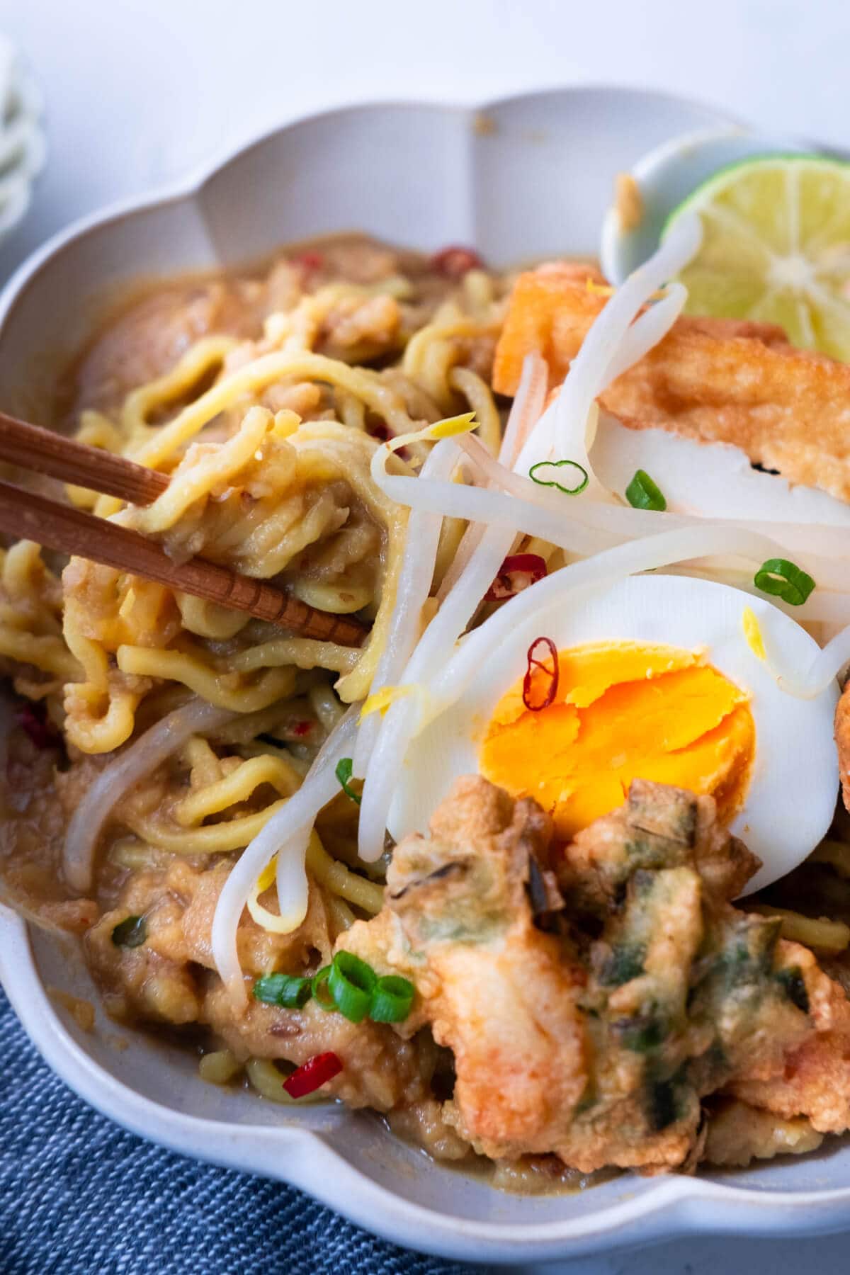 Mee Rebus recipe topped with cucur udang (prawn fritters) and a hard-boiled egg.