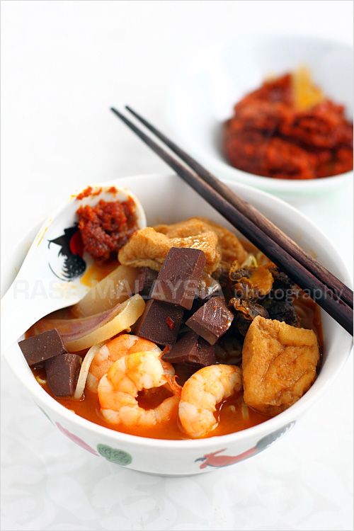 Penang Curry Mee recipe - With toppings many would consider bizarre: pig’s blood cubes (they taste like tofu except that they are maroon in color), bloody cockles, soaked cuttlefish slices, shrimp, and tofu puffs. | rasamalaysia.com