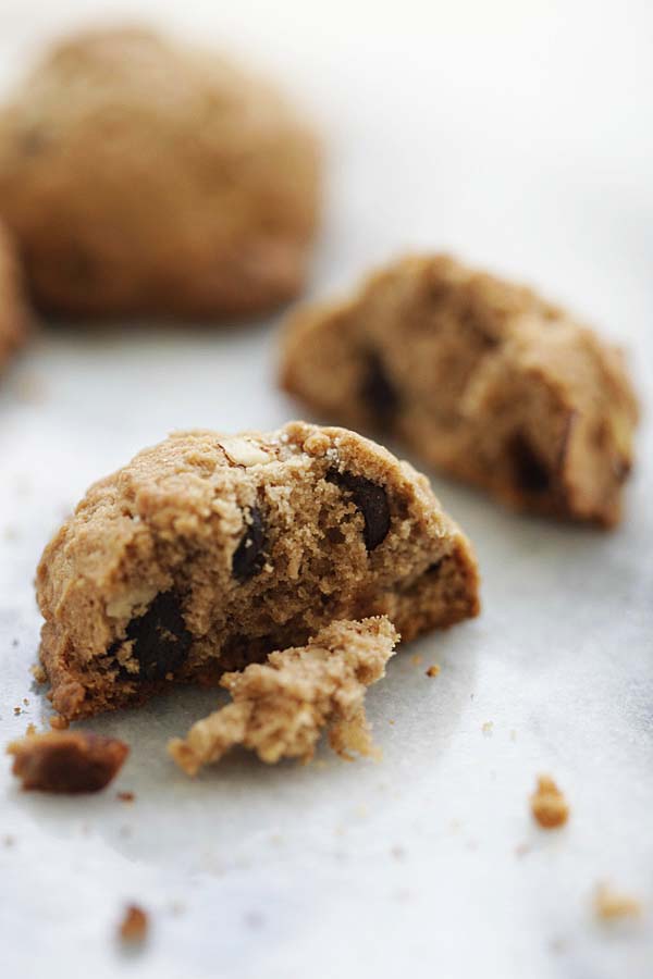 Chocolate chip cookies broken in half with the crumbs.