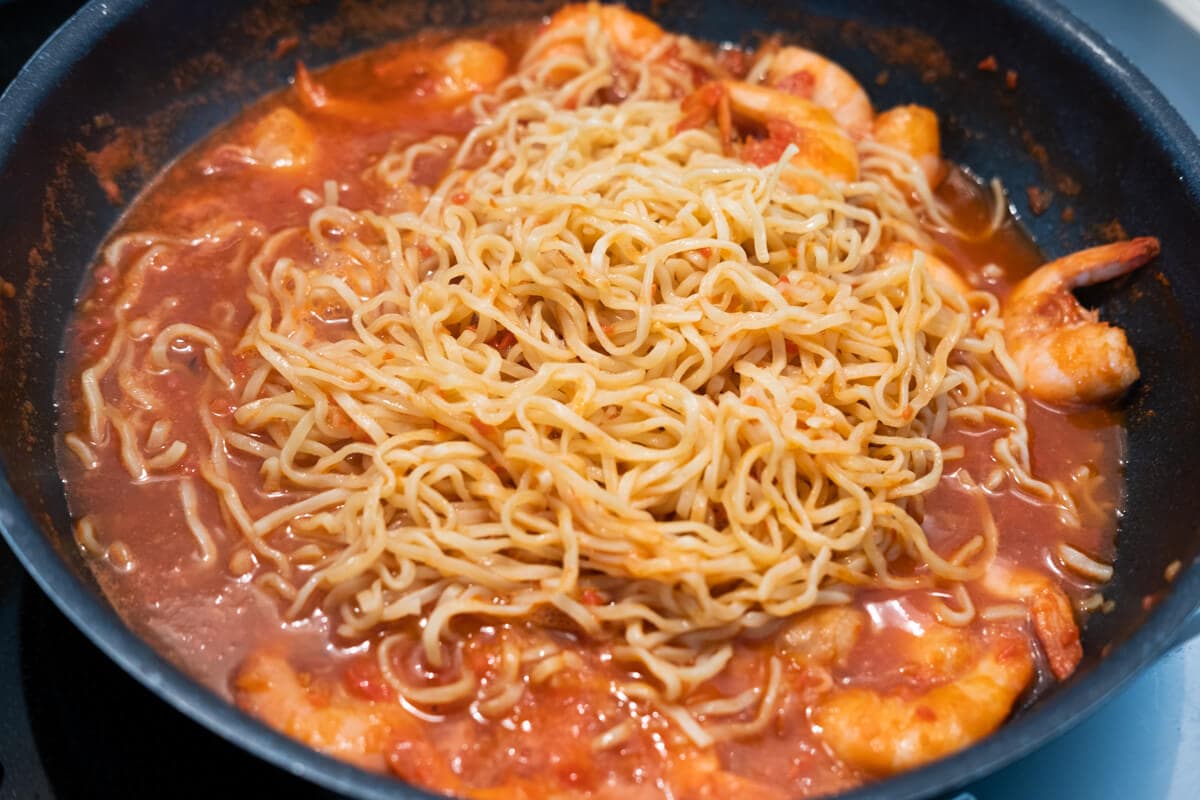 Add the noodles to the pan with the gravy and prawns.