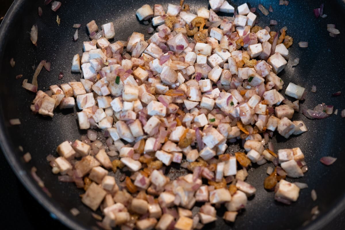 Stir-fry shallots, dried shrimps, and yam in a pan. 