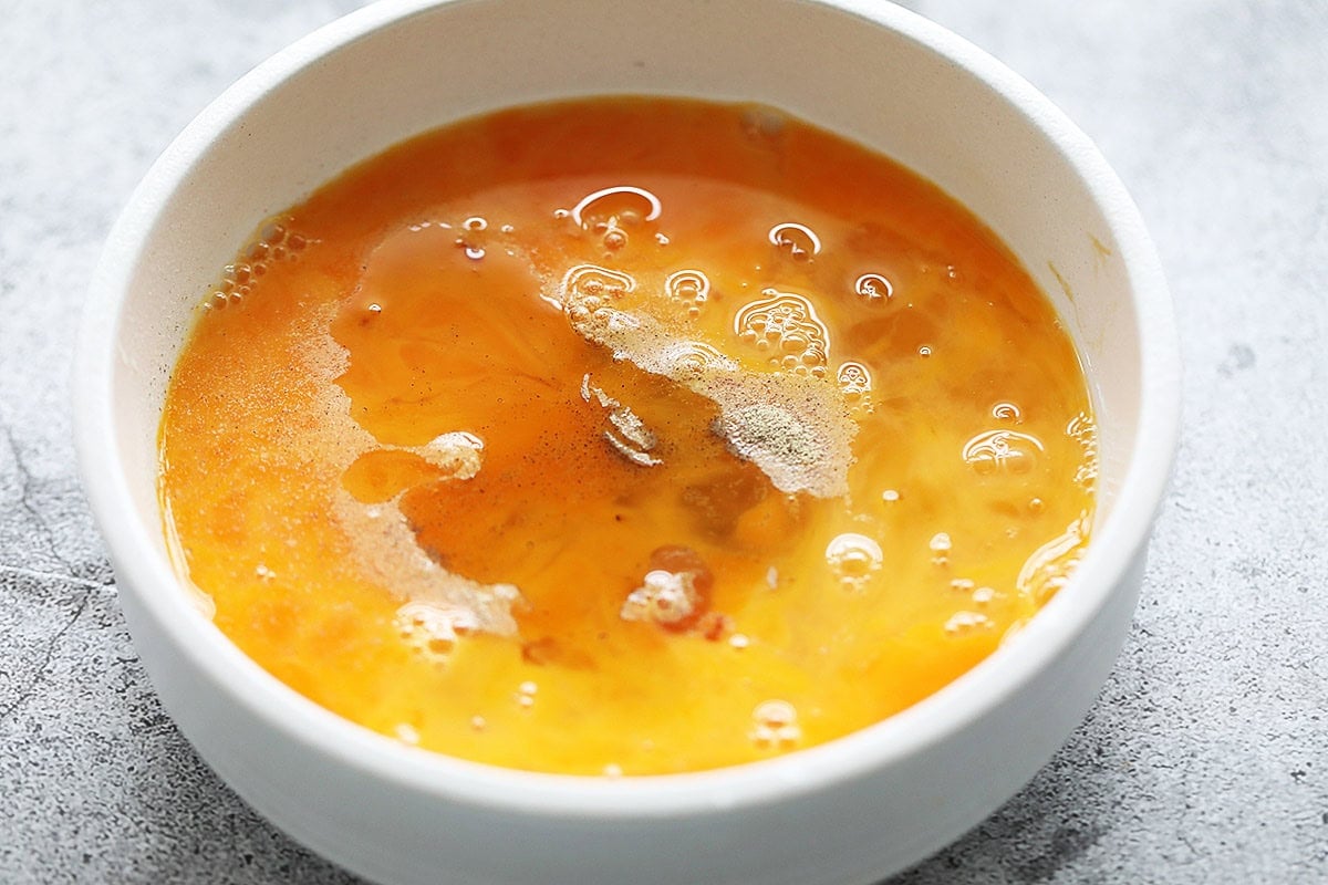 Eggs with seasonings in a bowl. 