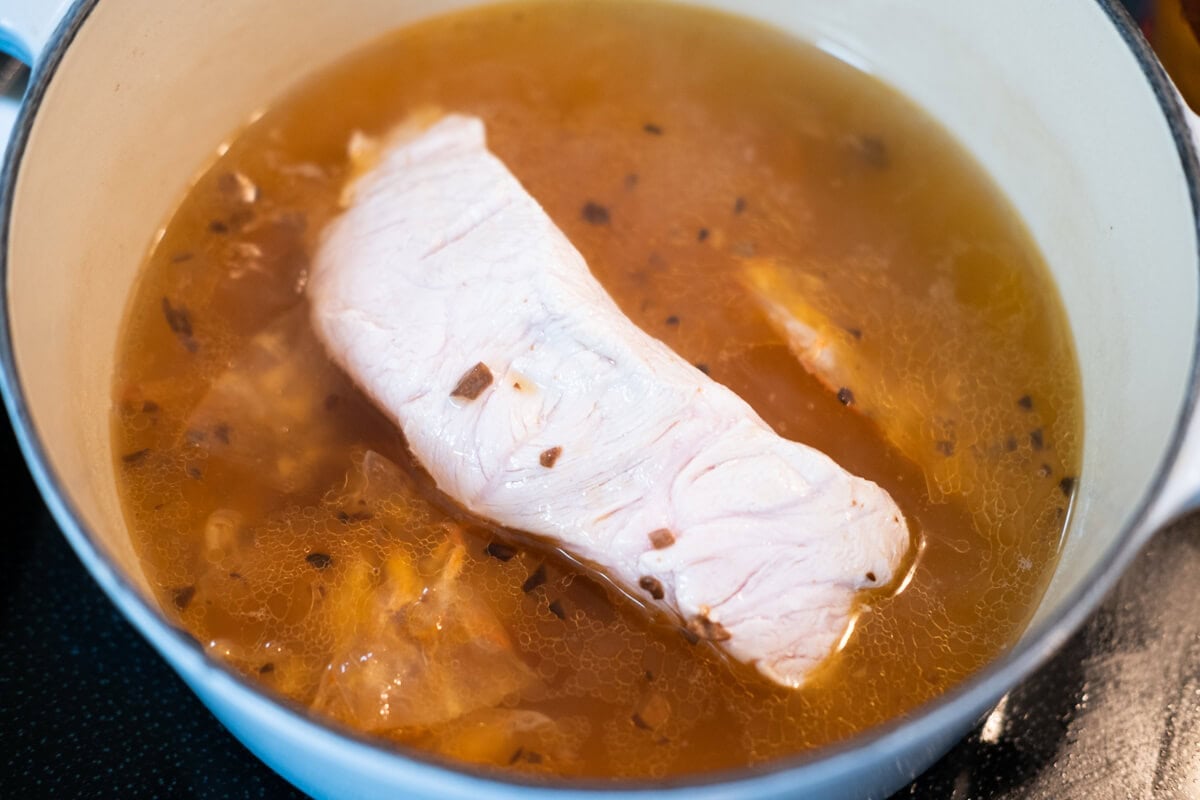 Add the pork to the chicken stock and cook it in the pot. 