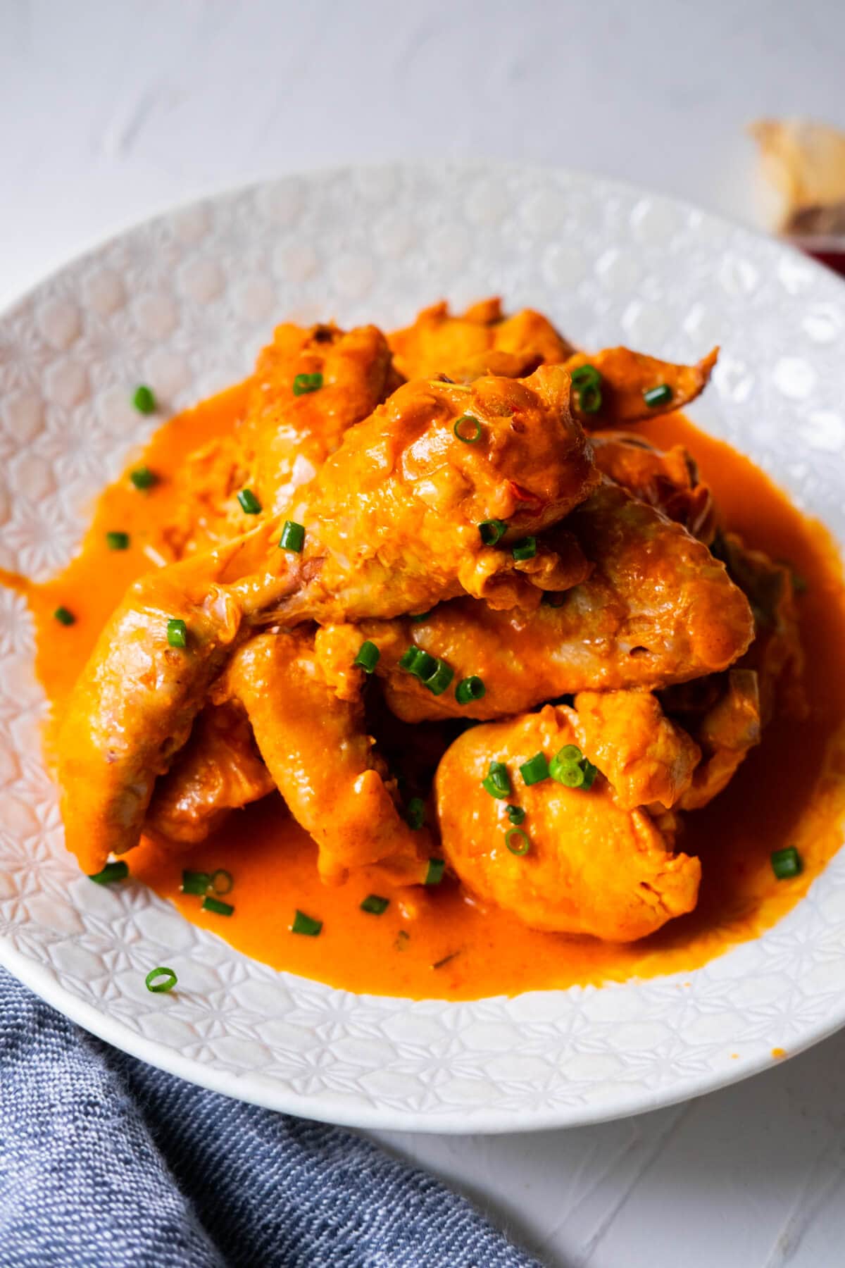 Ayam masak merah recipe served with chopped scallions on top.  