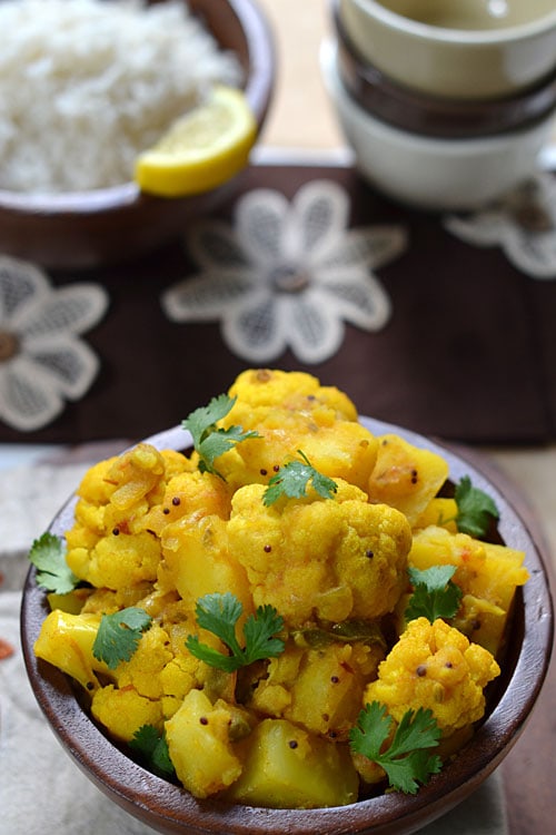 Close up of aloo gobi masala, with potatoes and cauliflower in a turmeric curry.