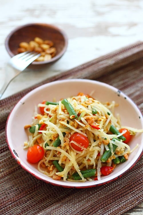 Homemade, healthy and easy shredded Thai Papaya Salad (Som Tum) recipe with green papaya, Peanuts, long beans and tomatoes.