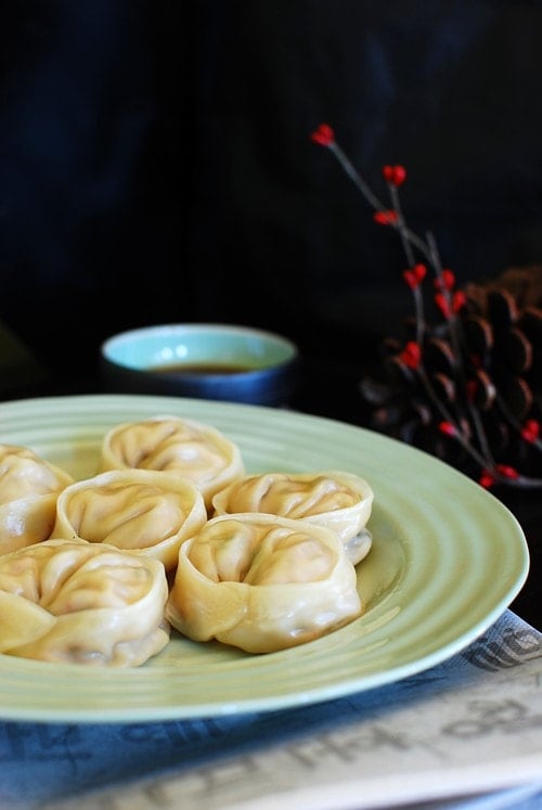 Easy Korean homemade kimchi dumplings steamed and served in a plate.