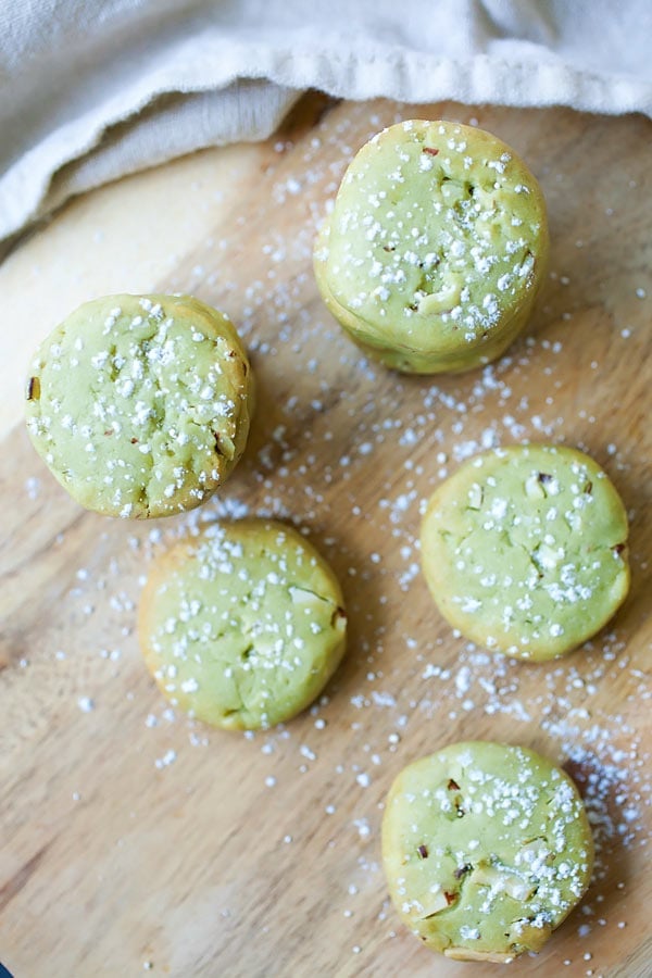 Top down view of easy homemade Japanese matcha cookies with almond dusted with powdered sugar.