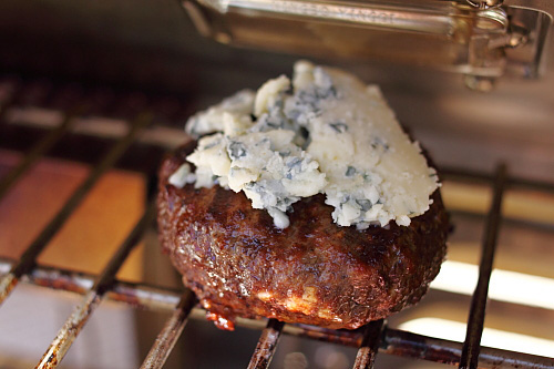Juicy and delicious Cabernet and Gorgonzola burger sliders patty on a grill.