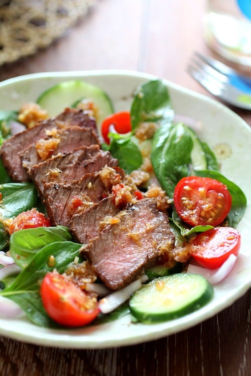 Healthy and easy Thai seared beef salad with basil leaves, tomatoes and a spicy Thai dressing.