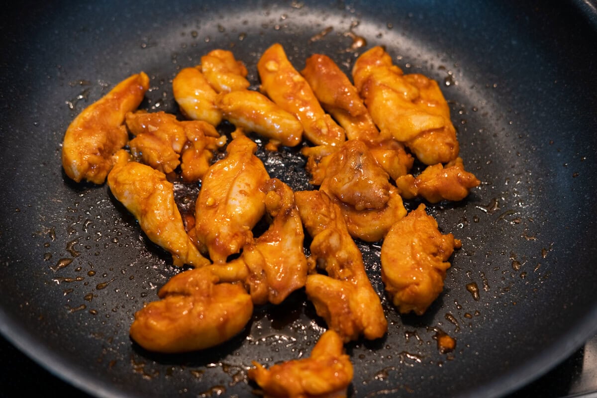 Korean spicy chicken bulgogi pan fried on a hot pan. 