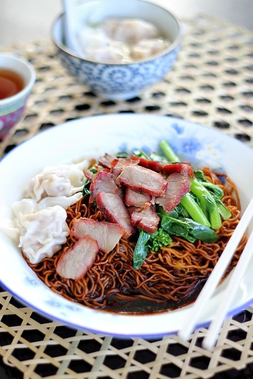 Wonton noodles with dark sauce on a plate.