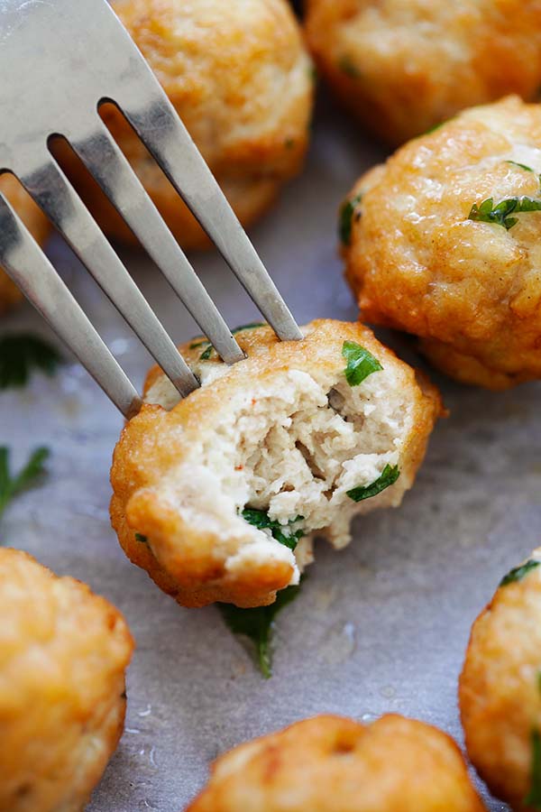 Asian chicken meatballs pierced with a fork. 