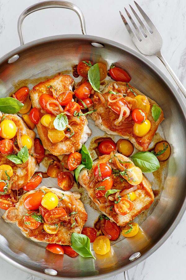 Sauté Pork cutlet with tomatoes and garlic in a skillet.