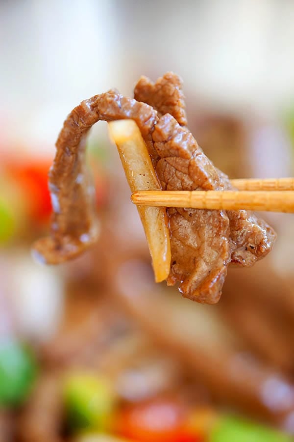 Easy and quick stir fry Chinese black pepper steak beef picked with a pair of chopsticks.