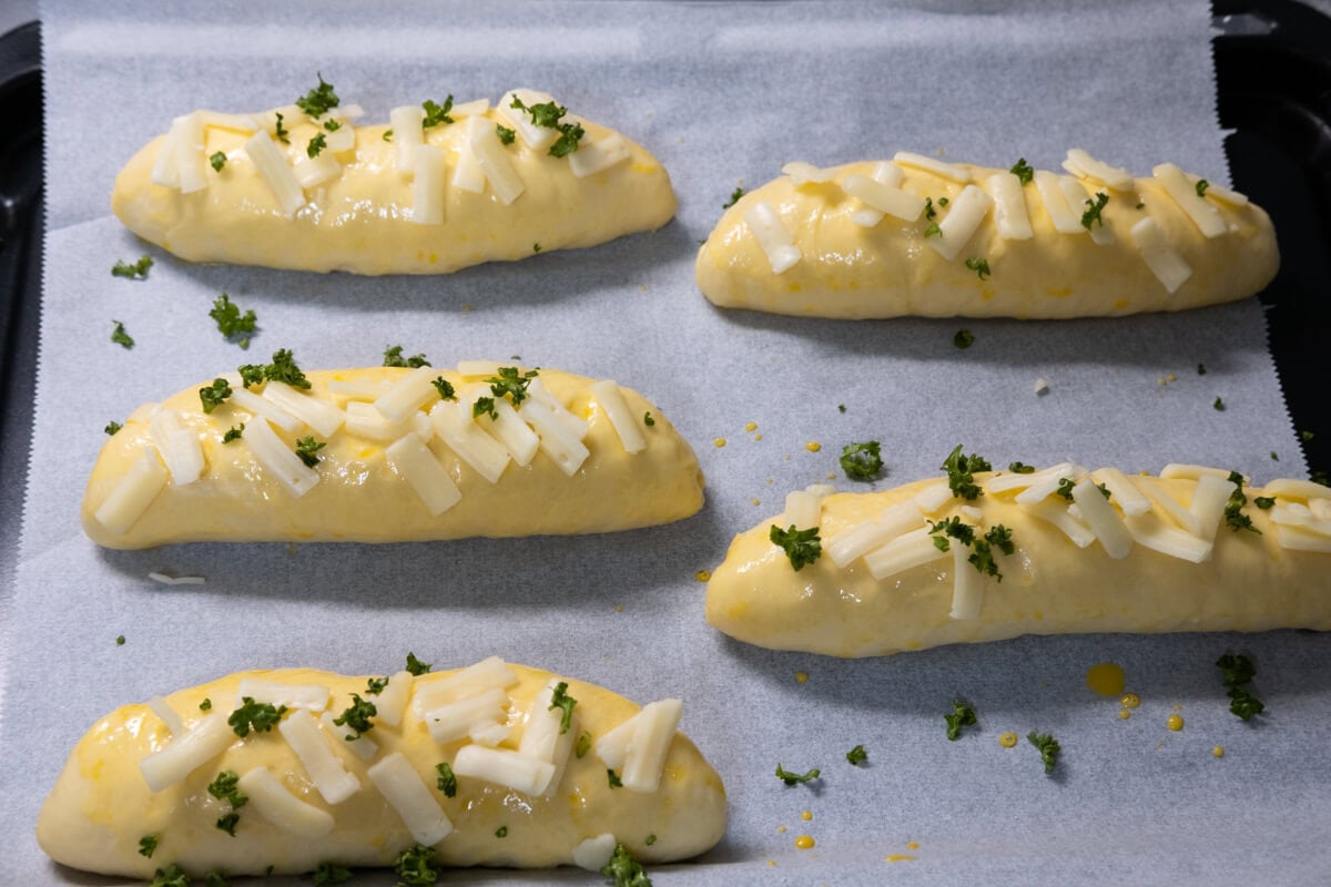 Cheese breadsticks topped with mozzarella cheese and parsley. 