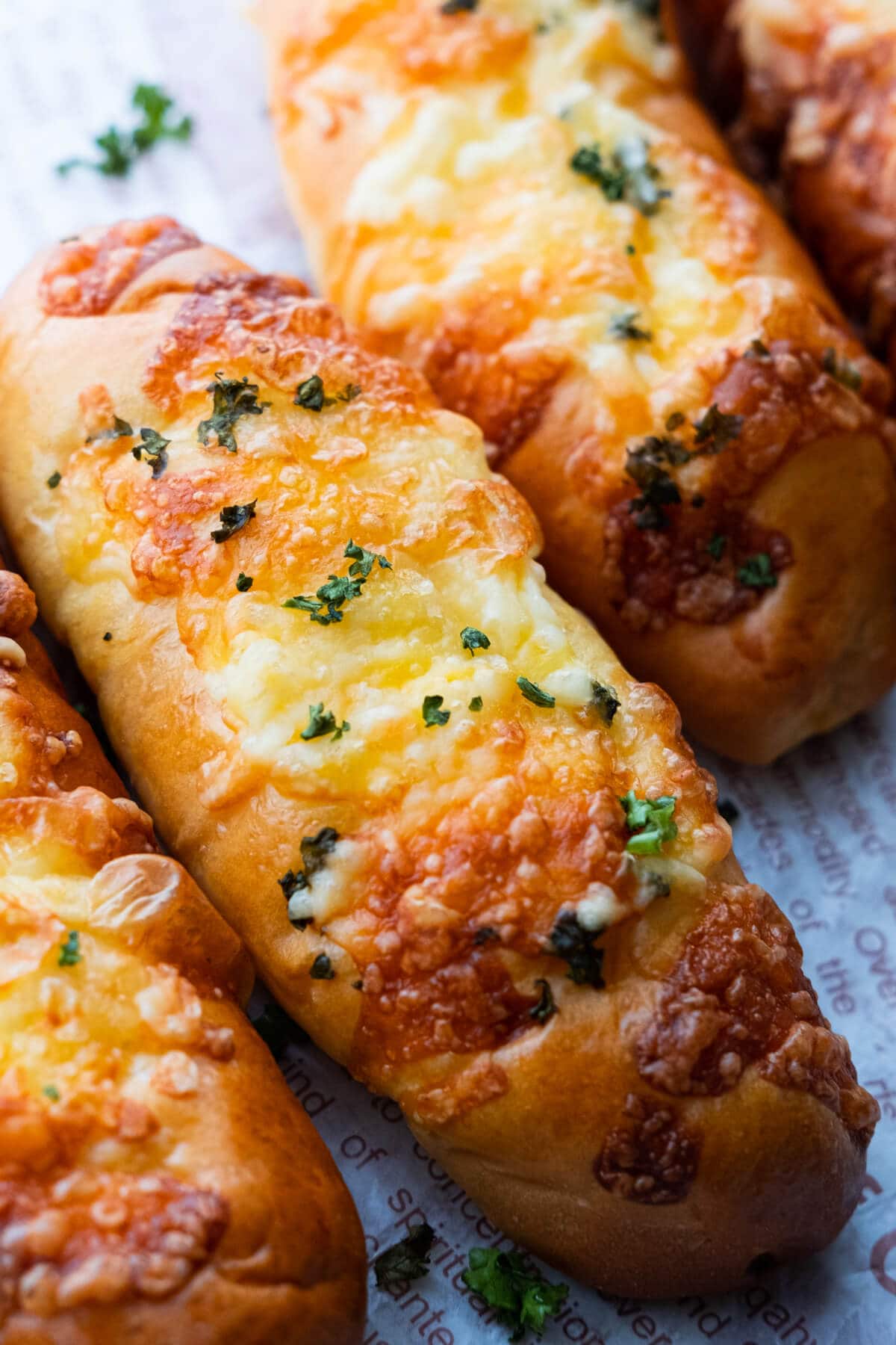 Breadsticks with cheese topped with chopped parsley. 