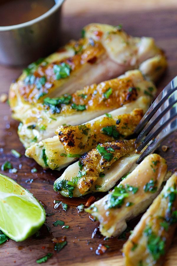 Easy and quick grilled Vietnamese lemongrass cilantro chicken sliced and placed on a wooden chopping board.