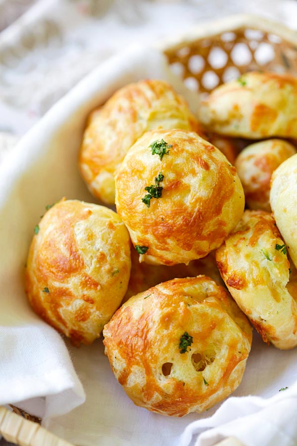 Close up picture of baked cheese puff balls (cheese balls) or gougeres recipe in a serving basket.