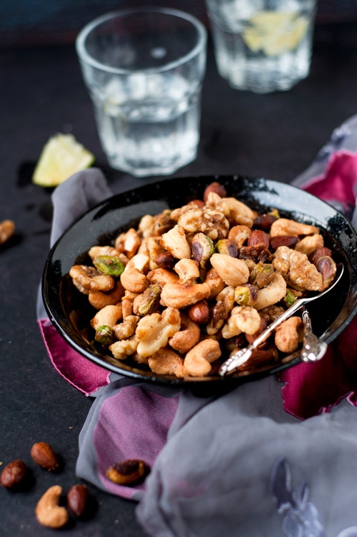 sweet, salty, spicy party nuts for holidays, served in a plate.
