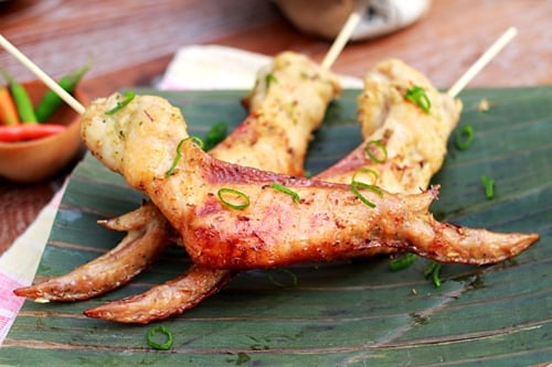 Easy and quick Southeast Asian chicken wings in skewers, placed on a banana leaf.