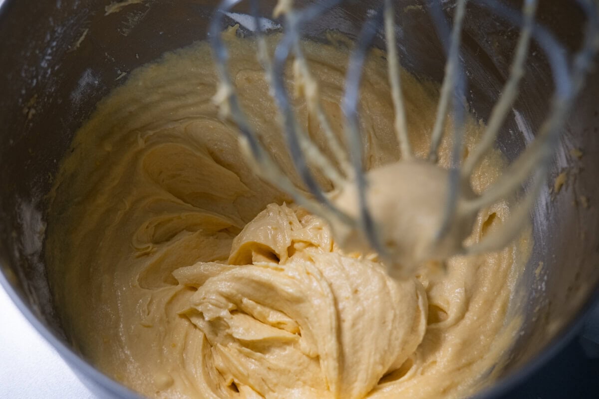 Orange cake batter in a stand mixer. 