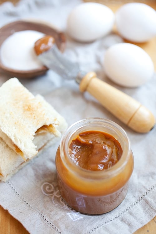 Asian authentic coconut egg kaya jam pasted on white toasted bread next to a jar of kaya jam.