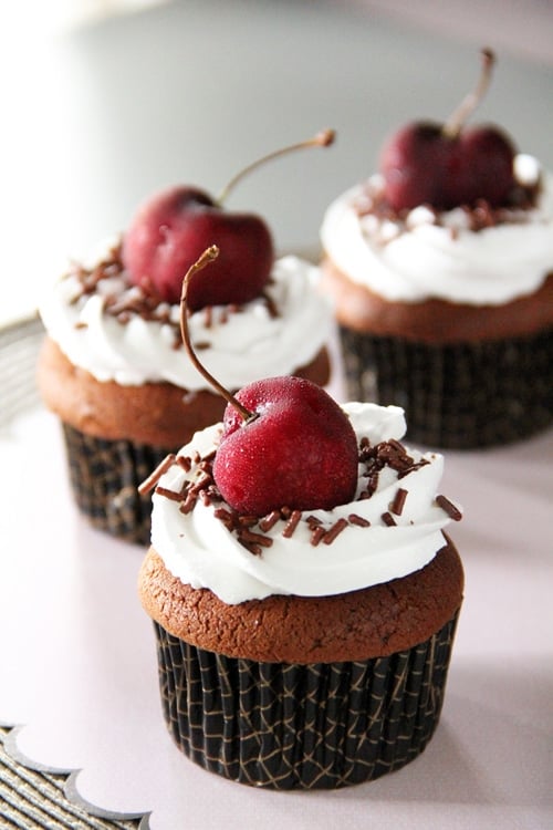 Enkla black forest cupcakes med vispgräddsglasyr, chokladströssel och körsbär.