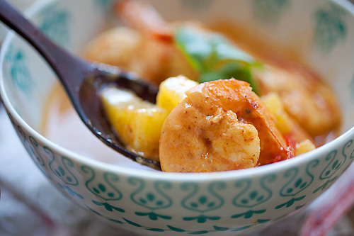 Tasty Thai red shrimp curry with pineapple and coconut, picked with a spoon.