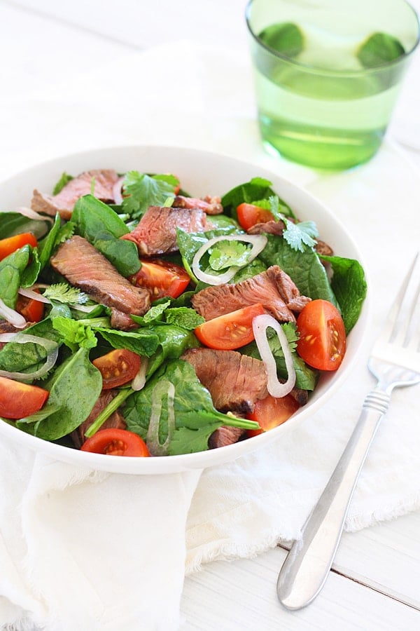 Thai Beef Salad with flavorful mint, cilantro and spinach in serving bowl.