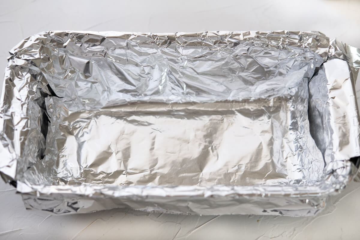 Loaf pan lined with aluminum foil.