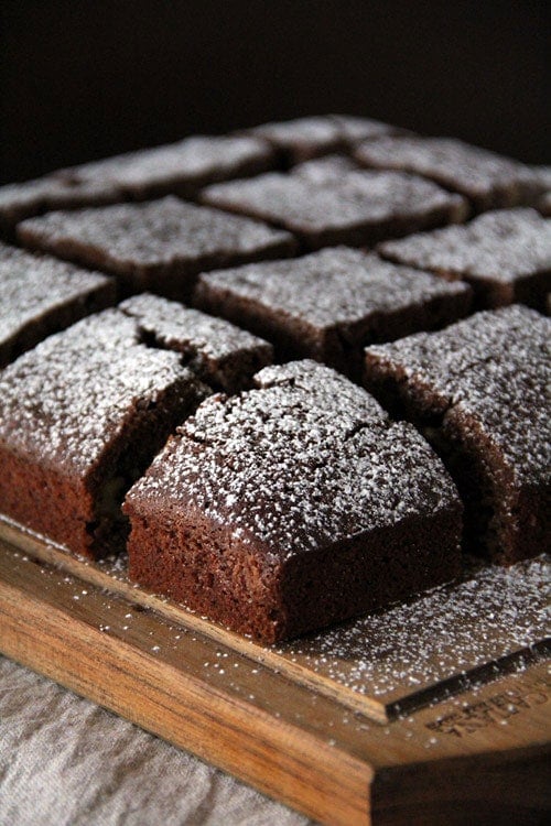 Easy homemade chocolate chip brownies sliced in square pieces, dusted with Confectioner's sugar.